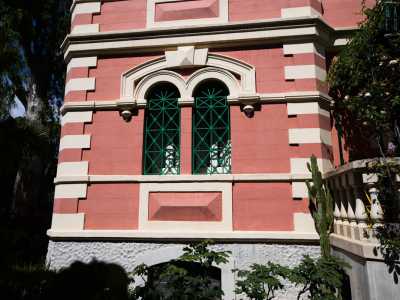 ...presenta raffinate finestre monofore e bifore con persiane e imposte verdi...